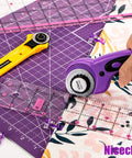 Rotary Cutter Set With 45mm And 28mm Fabric Cutters, self healing cutting mat, quilting rulers, and fabric in use.