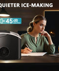 Nugget ice maker on countertop with handle; black portable appliance beside a person writing.