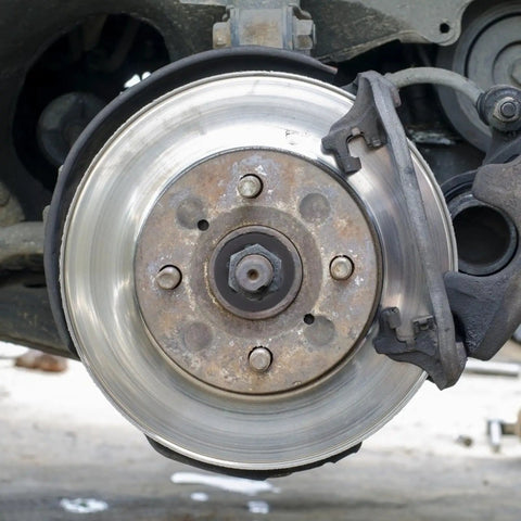 Close-up of a car brake disc and caliper, suitable for use with Internal Tooth Lock Washers Push On Clips Fasteners Assortment Kit.