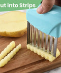 Two-piece stainless steel crinkle cutter set with teal handles for cutting potatoes into wavy strips on a wooden board.