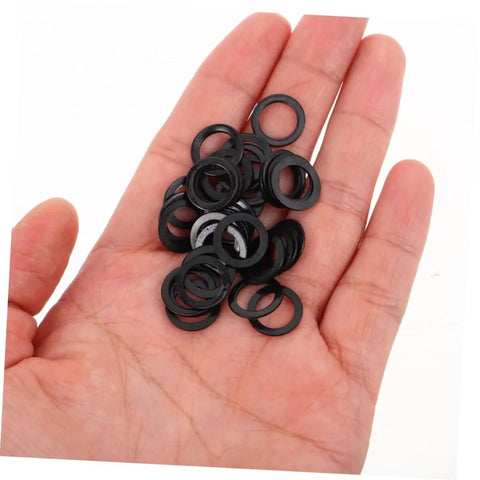 Hand holding black washers from 100 Pcs Skateboard Bearing Washers And Hardware Kit For Trucks And Longboards, Speed Washers, Spacers, Nuts And Bolts