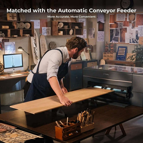 xTool P2 CO2 laser cutter in a workshop; a person loads a long plywood board into the machine