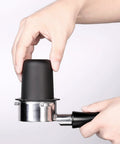 Hand placing 53.3mm Portafilter Dosing Cup in 304 Stainless Steel with Matte Black Nonstick Finish onto Breville portafilter.