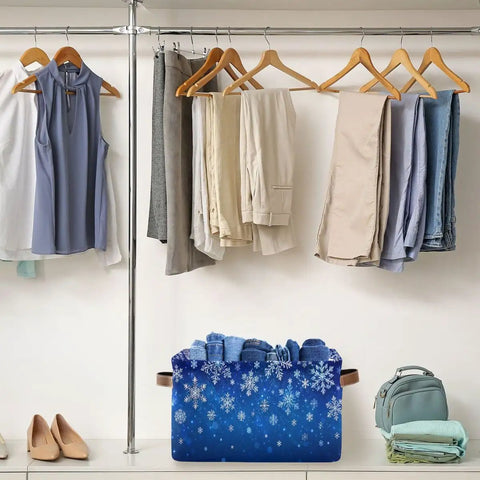 Dang Cool Canvas Storage Basket With Sparkly Winter Snowflake Pattern storing folded clothes under hanging garments in a closet.