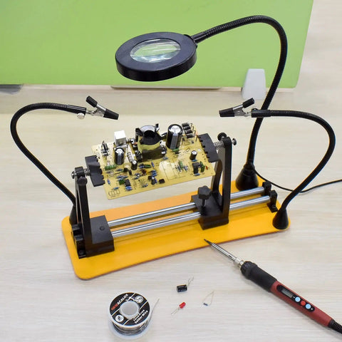 Helping Hands Magnetic Soldering Station with Pro Grade 360 Degree Flip, two flexible gooseneck arms, 3X magnifying glass over PCB