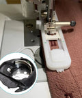 Must-Have Universal Bobbin Case For A Ton Of Sewing Machines Compatible With Brother And Baby-Lock Replacement Parts XC3152221 XE7560001 For SE400 SE600 SE625 CS6000I PE800 LX3817 And More. White plastic bobbin case installed in a sewing machine, black metal case inset