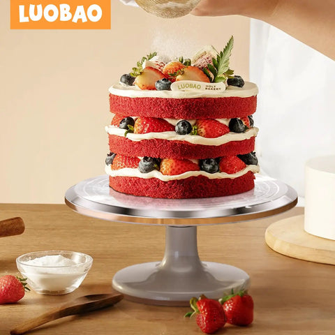 12 Inch Aluminum Cake Turntable Decorating Stand With Rotating Cake Stand Go To Kit For Cakes And Pastries Including Leveler Icing Comb Set 8 Pro Grade Decorating Tips Reusable Coupler And 10 Disposable Pastry Bags displaying a layered cake being decorated on the stand