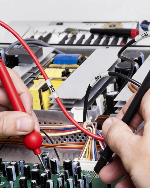 Top Shelf Heat Shrink Label Tape Compatible With Hse221 Refill Roll used on wires in electrical testing with multimeter.