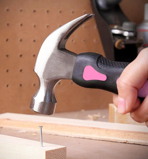 Close-up of pink ribbon stubby hammer from 4 Piece Stubby Tool Set for Small Hands and Tight Spaces in use, driving a nail.