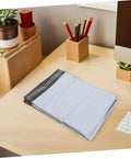 White Poly Mailer Bags 100 Pack 10x14 Inch Waterproof Self Seal Envelopes on desk