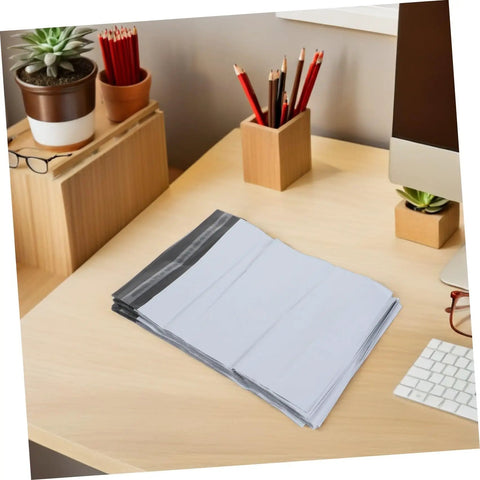 White Poly Mailer Bags 100 Pack 10x14 Inch Waterproof Self Seal Envelopes on desk