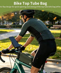 Cyclist riding with Bolt-On Top Tube Bike Bag With Magnetic Flap For Quick Access During Rides, Front Frame Storage Pouch in park.