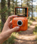 Hand holding 4K Magnetic Action Camera With 48MP Sensor Dual Battery System 2.0 Inch Flip Touch Screen EIS Stabilization in orange