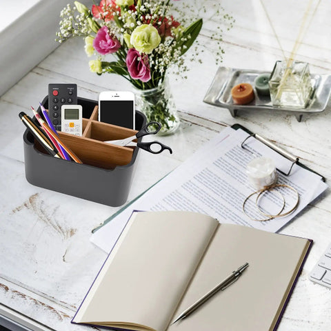 Black Desk Organizer And Remote Holder With Pen And Phone Slot on workspace with notebooks and flowers