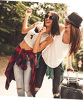 Two women outdoors with luggage during a sunny day adventure