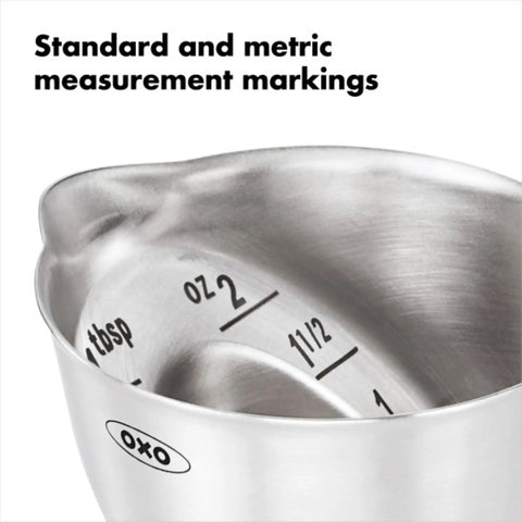 Close-up of stainless steel angled jigger with dual ounce and tablespoon markings, showing easy reading from above design.