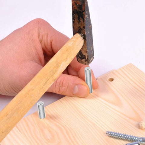 Person hammering 100 Pcs 304 Stainless Steel Cylindrical Dowel Pins 5x40mm for machinery onto wood surface.