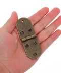 Hand holding a 180 degree butterfly cabinet hinge with round edges from the four pack for furniture doors and projects.