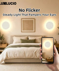 LUXLUCIO Hardwired 9" Round Backlit White Modern Indoor LED Wall Sconce illuminating a cozy bedroom.
