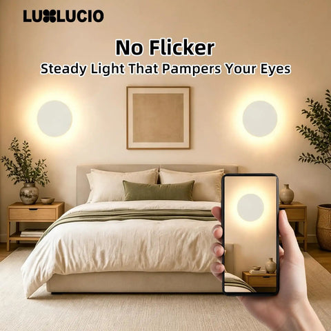 LUXLUCIO Hardwired 9" Round Backlit White Modern Indoor LED Wall Sconce illuminating a cozy bedroom.