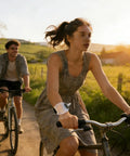 Cyclist wearing Hands Free Wrist Water Bottle For Running And Cycling With Secure Strap, enjoying outdoor biking, sunlit path.