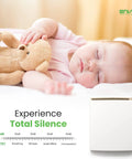 Sleeping baby with teddy bear next to plug in wall panel heater for indoor use delivers energy efficient low wattage comfort.
