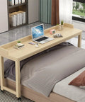 Roomy Rollin Overbed Laptop Desk Featuring Sturdy Guard Rail And Smooth Lockable Wheels Solid Wood Bedside Tray on bed with laptop.
