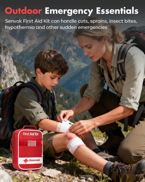 Front view of red Senvok first aid kit on rocky ground as adult wraps knee of child outdoors