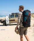 Person carrying Beast All In One Inflatable Wing Surf Gear Set With PVC Wing Board 3.2 Square Meters on beach near SUV