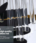 Close-up of sleek glass rods on a gold crystal wall sconce with modern vibe, stainless steel base, held in gloved hand.