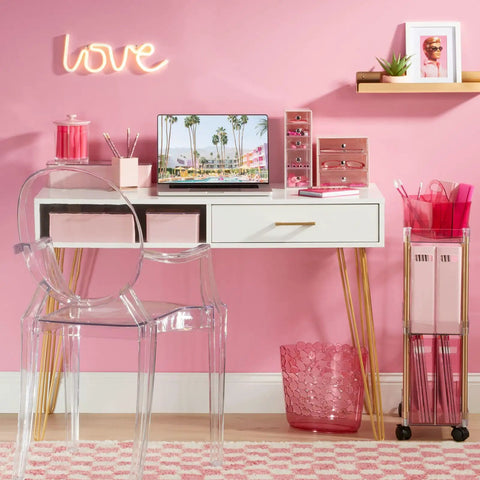 Light pink and clear office setup with stackable plastic storage organizer boxes with hinged lids on a desk