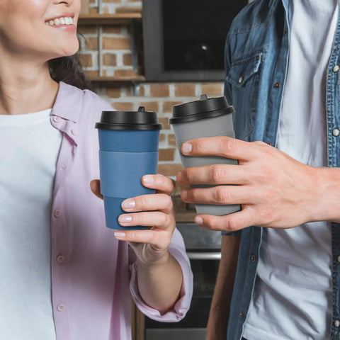 Hands holding blue and gray 16 Oz Disposable Paper Coffee Cups With Lids, Sleeves, And Stir Sticks, Blue And Gray, 100 Pack.