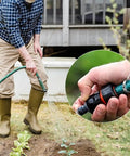 Gardener using hose with Stainless Steel Irrigation Hose Clamps 6 Pack Double Line Spring Clips for Drip Irrigation Systems.