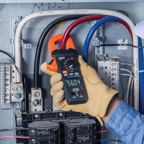 Electrician using Digital Clamp Meter With True RMS And LoZ Auto Ranging For AC And DC Voltage And Current in electrical panel