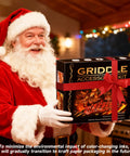 Santa holding Griddle Accessories Kit For Blackstone Griddles, 28 Piece Hibachi Tools Set gift box tied with red ribbon.