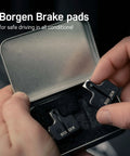 Person holding two pack bike brake pads for Magura MT5 MT7 hydraulic disc brakes replacement pads in metal box.