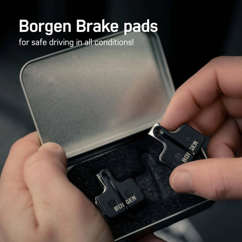 Person holding two pack bike brake pads for Magura MT5 MT7 hydraulic disc brakes replacement pads in metal box.