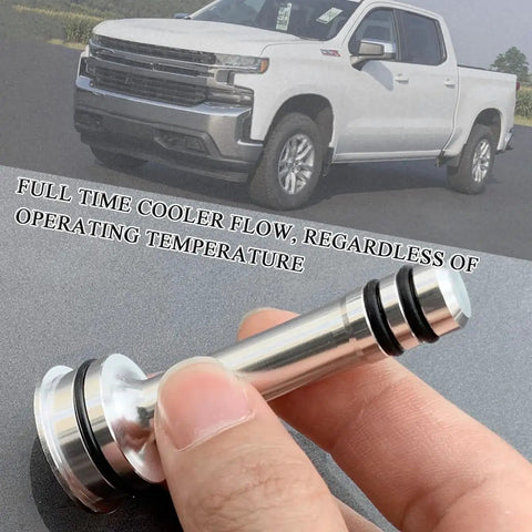 Hand holding Thermostat Bypass Kit for 6L80 6L90 and 8L90 Transmissions with CNC Machined Parts and O Rings; truck in background