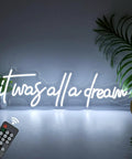 It Was All A Dream Neon Sign LED Wall Decor 27 By 8.5 Inch Timed Dimmable Neon Lights with remote on wall with plants.