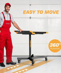Adjustable Height Mobile Work Table With Rolling Tool Cart And Drills Storage, Heavy Duty Metal Mechanic Workbench On Wheels For Garage, Workshop, And Bike Repair, Orange And Black with a mechanic standing next to it.