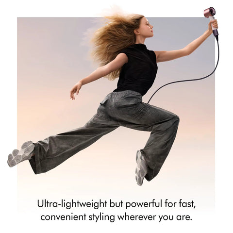 Person in motion holding Supersonic Travel Hair Dryer With Universal Voltage For On The Go Styling Ultra Lightweight And Compact Design.