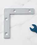 Solid L Shape Corner Brackets 2.17 By 2.17 Inches 100 Pcs Silver Iron Frame Reinforcement displayed with blue wrench on tabletop.