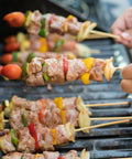 Grilled kebabs on 200 Pack Bamboo Skewers 12 Inch Wooden Kabob Sticks For Appetizers And Grilling, held over barbecue