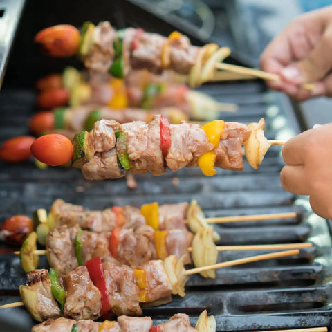 Grilled kebabs on 200 Pack Bamboo Skewers 12 Inch Wooden Kabob Sticks For Appetizers And Grilling, held over barbecue