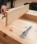 Digital Vernier Caliper 0-150mm Stainless Steel LCD(With battery) displayed on a wooden workbench with a hand adjusting a clamp.