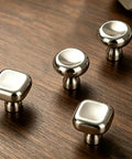 Slick Silver Cabinet Knobs and Drawer Pulls Set, Polished Zinc Alloy With Titanium Coating on wooden surface