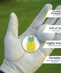 Golfer's hand holding Pineapple Shaped Golf Ball Marker For Alignment And Game Changer Putting Green Precision Metal Ball Marker 1 Inch Wide