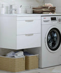 Laundry room setup with Bosch dryer beside sink cabinet, featuring stacked towels and baskets below.