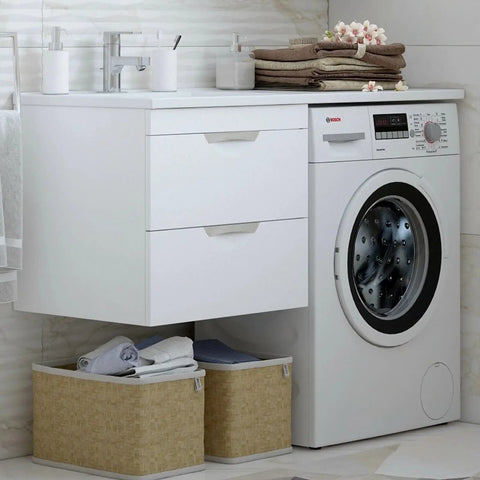 Laundry room setup with Bosch dryer beside sink cabinet, featuring stacked towels and baskets below.