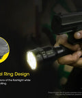 Person holding TM9K TAC 9800 Lumen USB C Rechargeable Tactical Flashlight Bundle alongside a gun with tactical ring design detail